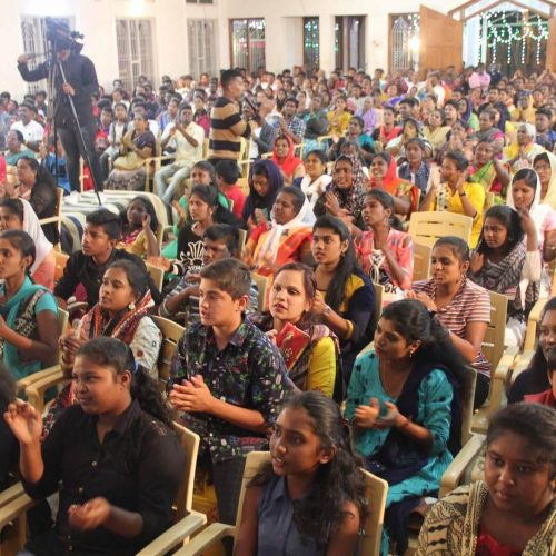 Fully packed church with young children and young adults