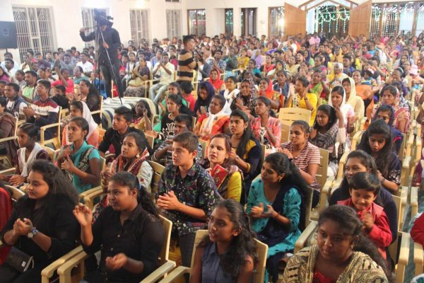 Fully packed church with young children and young adults